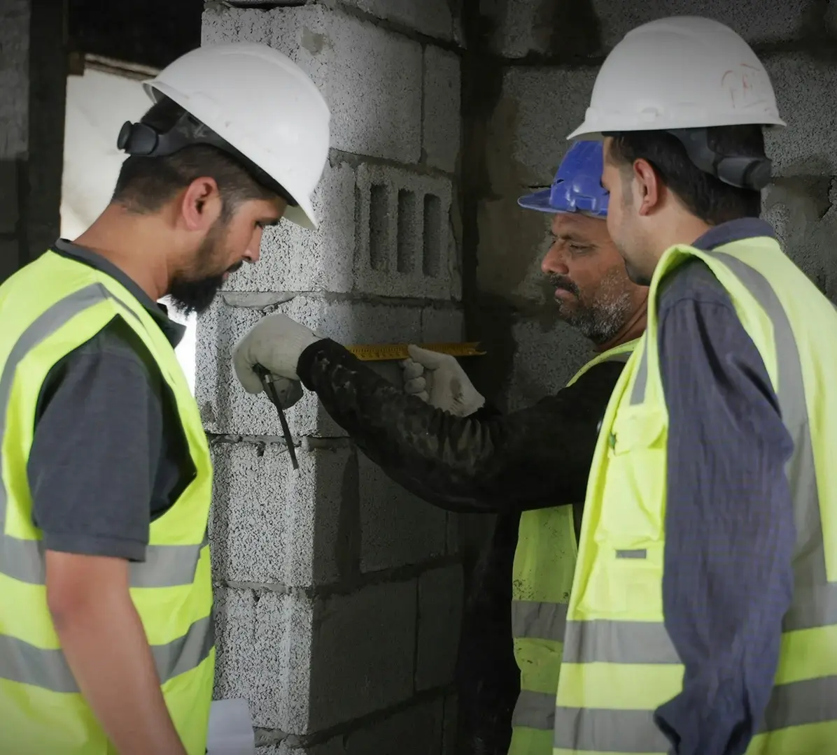 construction-team-measuring-concrete-block-wall