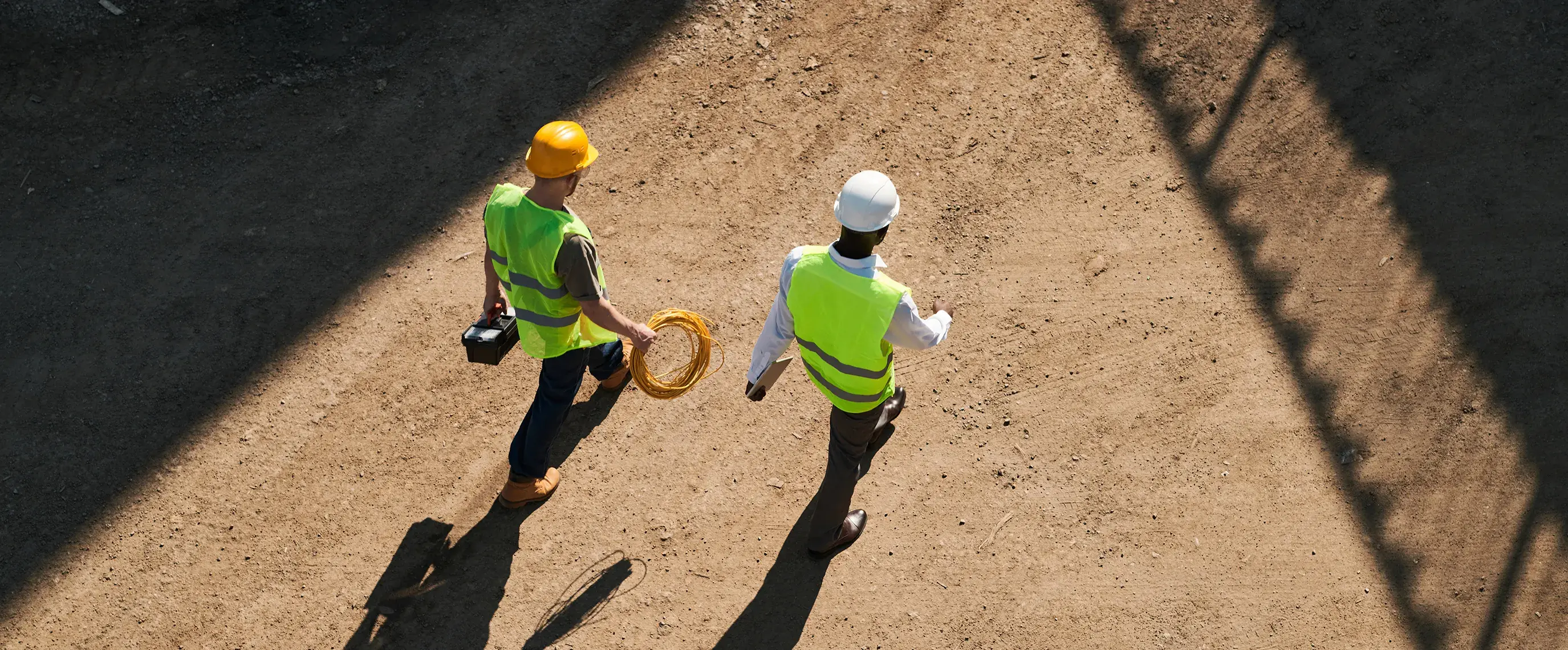 construction-workers-walking-site-with-tools-aerial